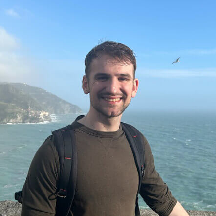 Nathan Affleck in front of a sea and blue sky background